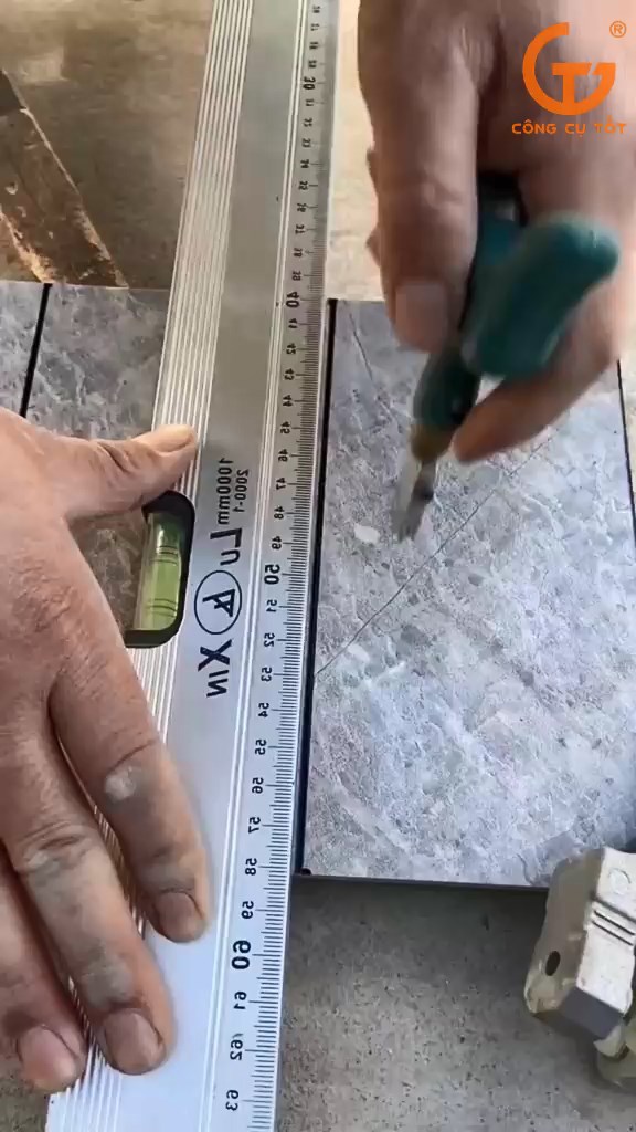 Người thợ sử dụng thước thủy nivo để xác định vị trí cần cắt 