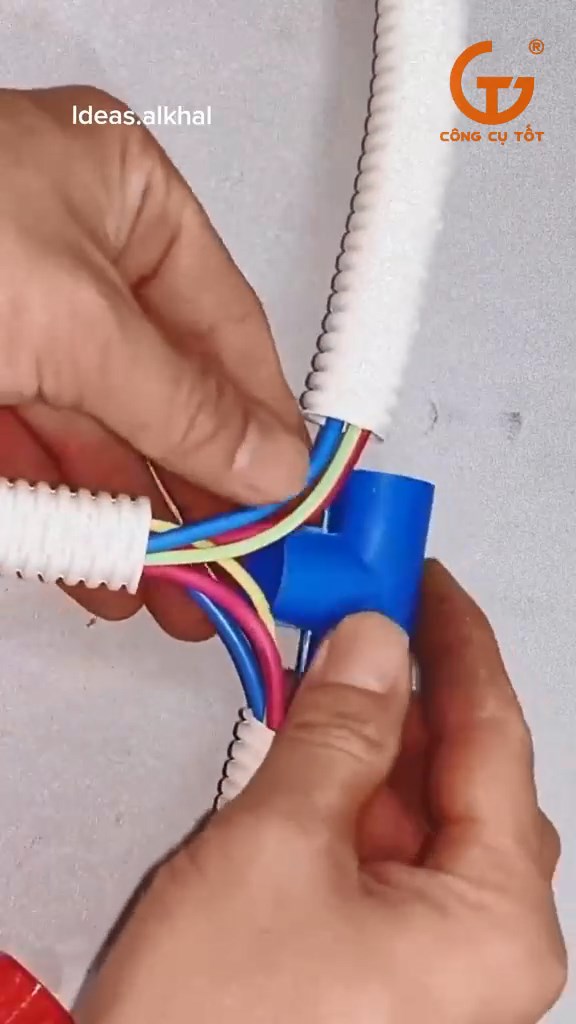 Luồn dây điện cùng ống ruột gà vào trong chiếc tê nhựa
