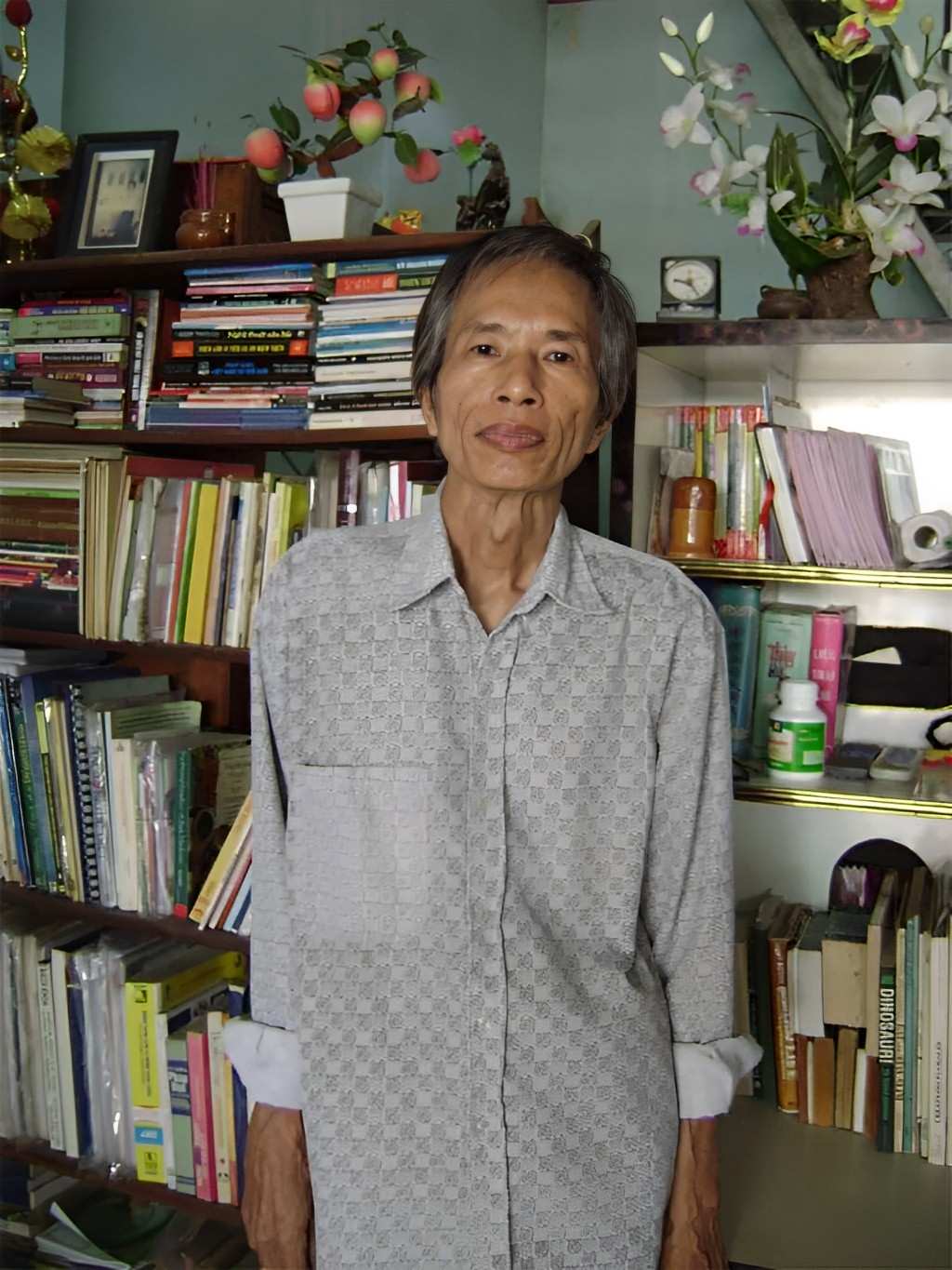 Dịch giả, tác giả Phạm Cao Hoàn bên chồng sách tại nhà riêng